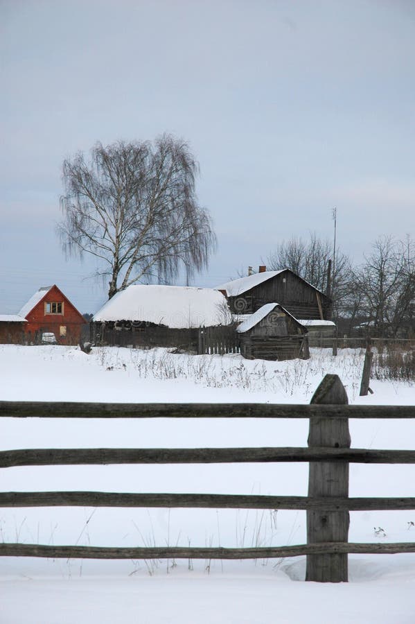 Wooden fence in winter village.