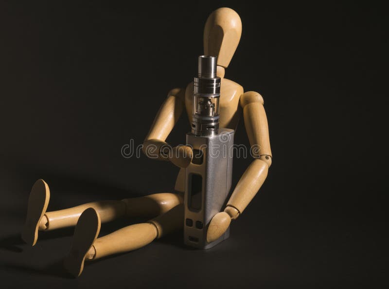 Wooden figure holding an electronic cigarette.