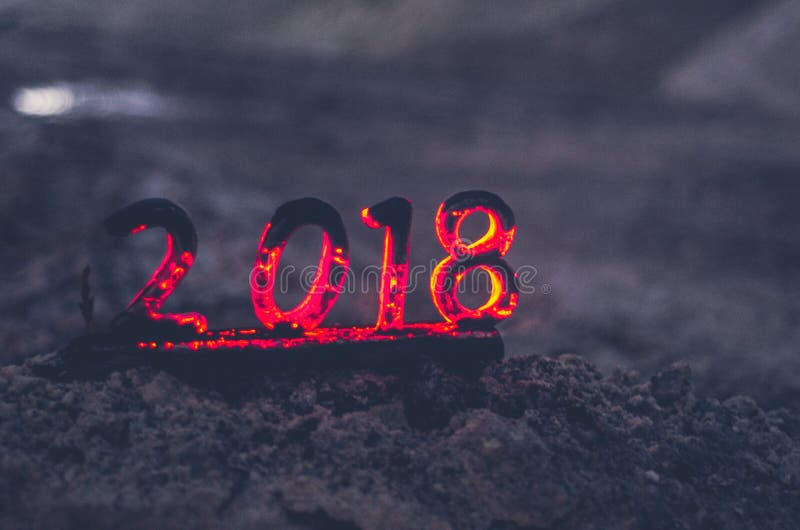Wooden figures 2018 are burned in a flame. Conceptual photo end of the year. stock image Wooden figures 2018 are burned in a flame. Conceptual photo end of the year. stock image