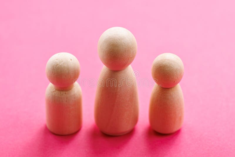 Wooden figurines on pink background - simple minimalist design royalty free stock photography