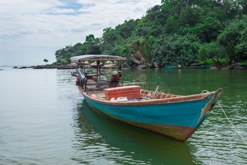 Wooden fishing boat in the blue and green waters of Cambodia