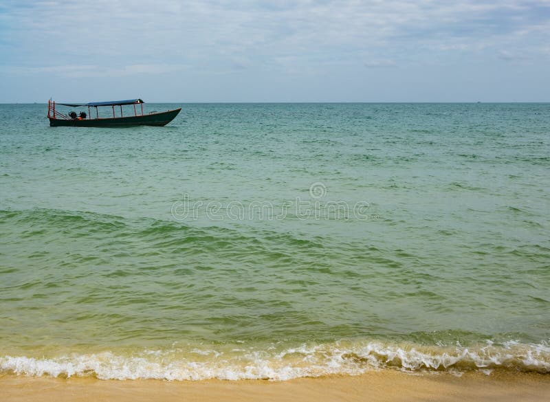 Wooden fishing boat in the blue and green waters of Cambodia