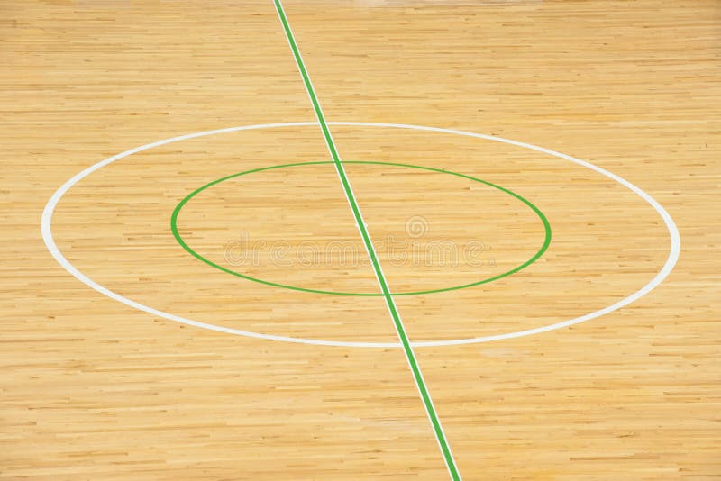 Wooden floor of sports hall with marking lines .