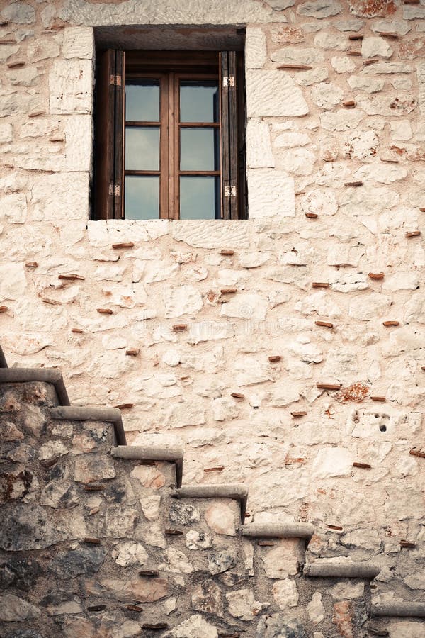 Wooden and glass window in a stone wall with stairs