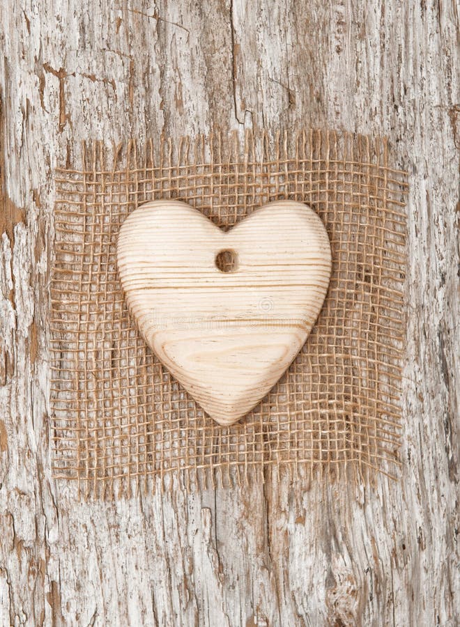 Drevené srdce s vrecoviny textilné na staré drevo pozadí.