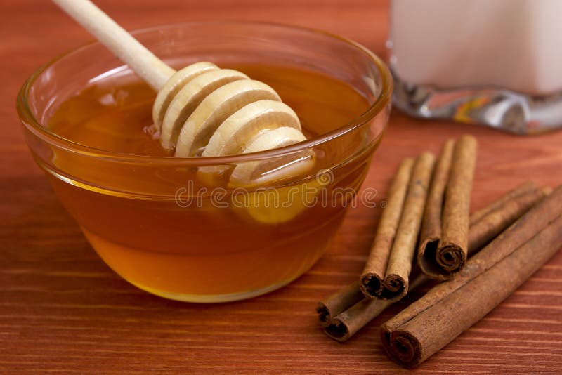 Wooden honey stick and cinnamon sticks.