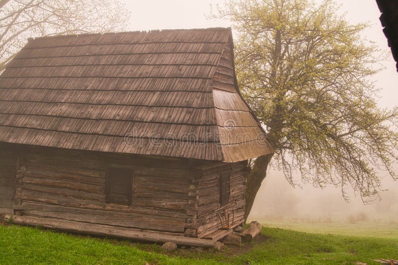 Wooden house in Podsip mountain village during misty morning in Sipska Mala Fatra mountains