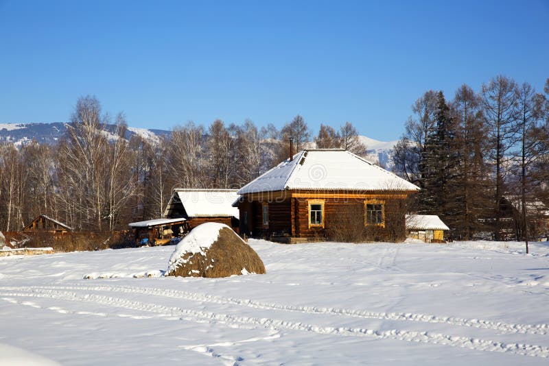 A wooden house in russian village Zamulta in winter in Uimon Valley, Altai mountains