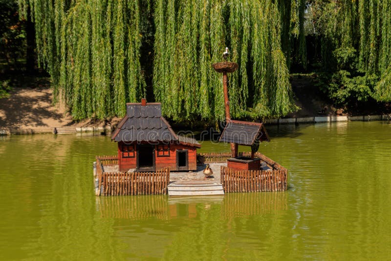 Wooden house for water birds and turtles on lake in city park stock photo