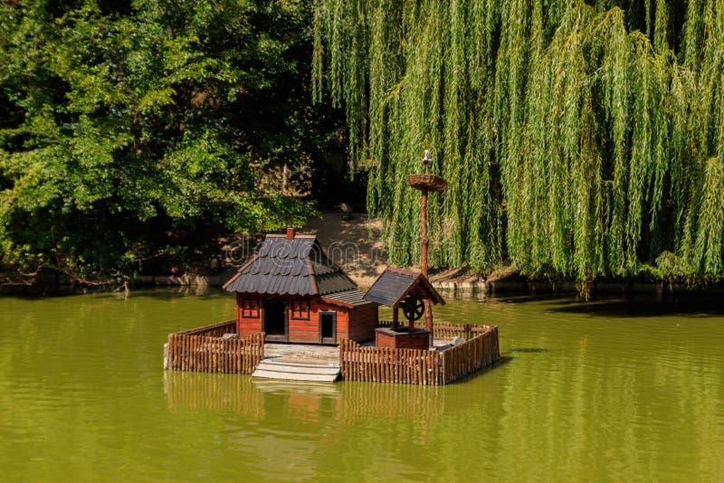 Wooden house for water birds and turtles on lake in city park royalty free stock image