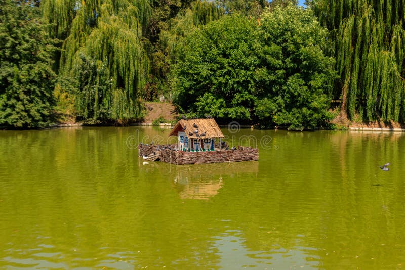 Wooden house for water birds and turtles on lake in city park royalty free stock photo