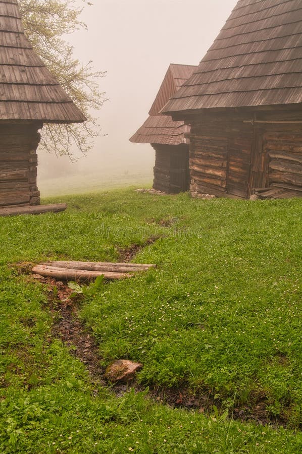 Wooden houses in Podsip mountain village during misty morning in Sipska Mala Fatra mountains