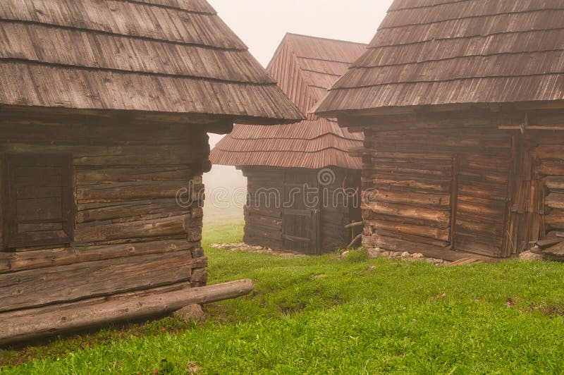 Dřevěné domy v horské vesničce Podšíp během mlhavého rána v pohoří Šipska Malá Fatra