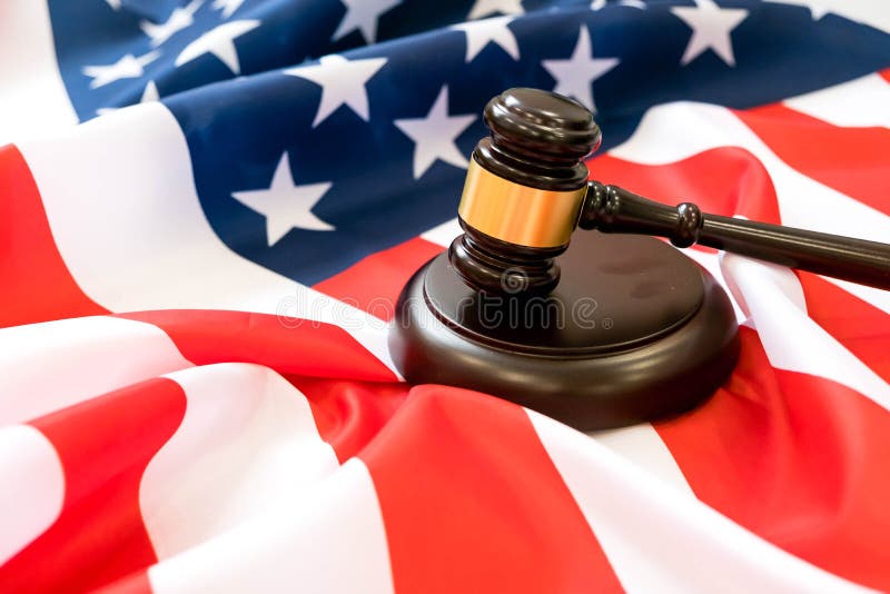 Wooden judge gavel and soundboard laying over US flag. Hammer and gavel. American law and justice concept. bidding