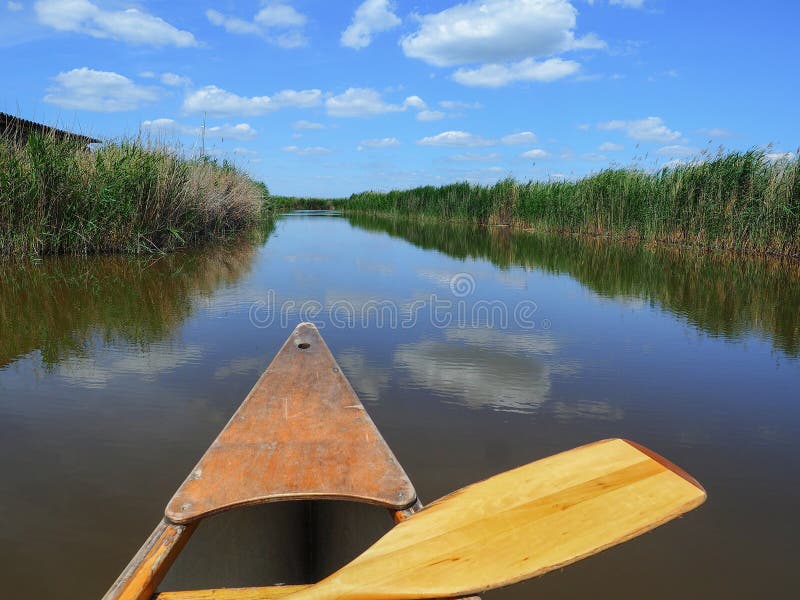 Wooden kayak with paddle on Neusiedler See Lake Neusiedl. Sunny summer day. Rust Burgenland Austria. June 2017. Wooden kayak with paddle on Neusiedler See Lake Neusiedl. Sunny summer day. Rust Burgenland Austria. June 2017