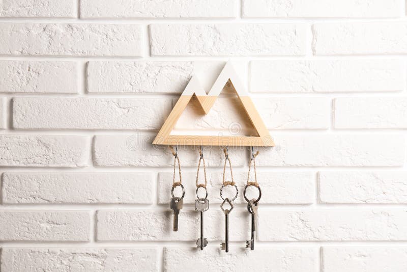 Wooden key holder on white brick wall