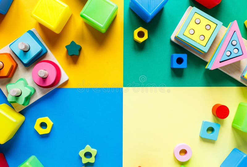 Wooden kids toys on colourful paper. Educational toys blocks. Toys for kindergarten, preschool or daycare. Copy space for text.