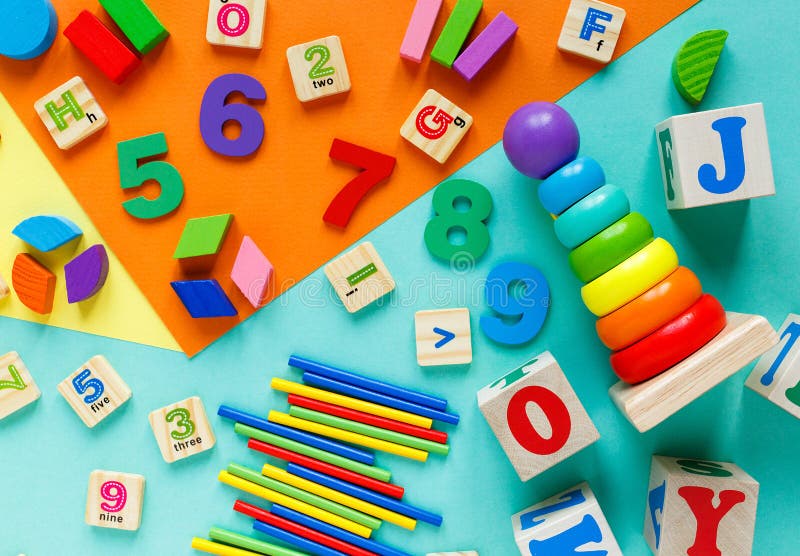 Wooden kids toys on colourful paper. Educational toys blocks, pyramid, pencils, numbers, train. Toys for kindergarten