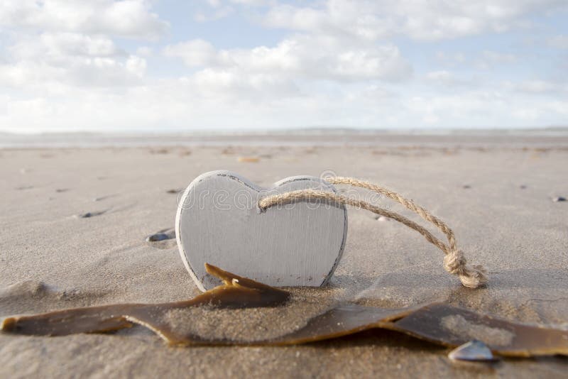 Wooden love heart in the sand