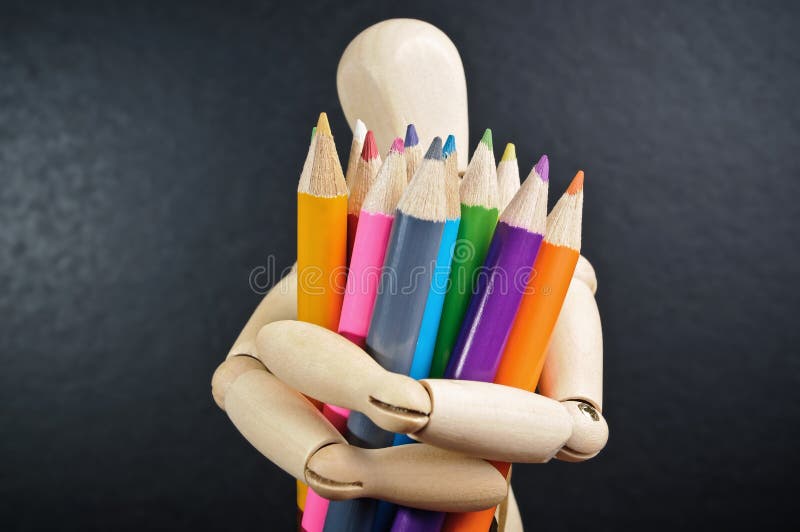 Wooden mannequin and color pencils