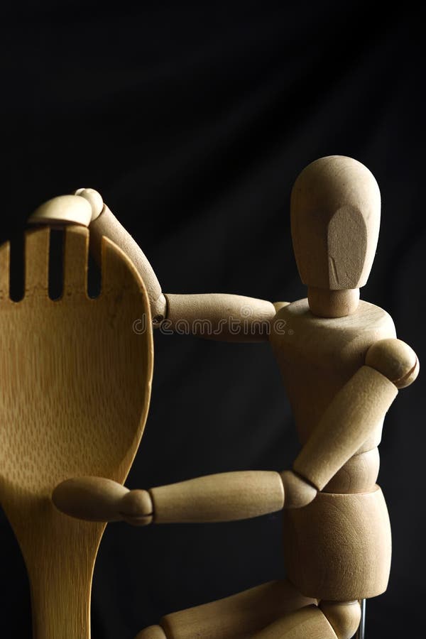 Wooden mannequin with a kitchen passion to the kitchen. Wooden Human Art Mannequin hugs a wooden spoon for salad, passion for modern cooking stock images Wooden mannequin with a kitchen passion to the kitchen. Wooden Human Art Mannequin hugs a wooden spoon for salad, passion for modern cooking stock images