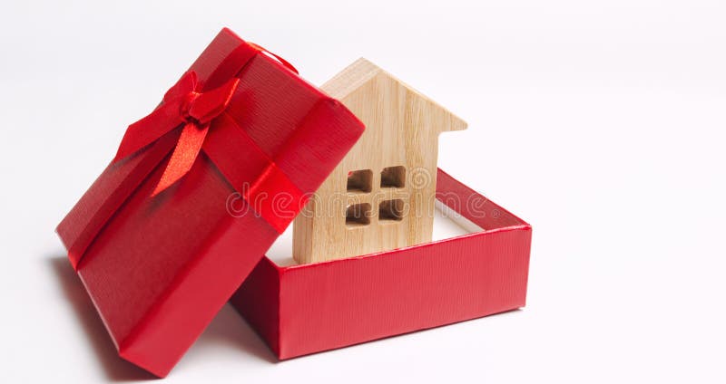 Wooden miniature house in a gift box. Housing as a gift. Win an apartment in the lottery. To inherit property. Holiday discounts. stock photography Wooden miniature house in a gift box. Housing as a gift. Win an apartment in the lottery. To inherit property. Holiday discounts. stock photography