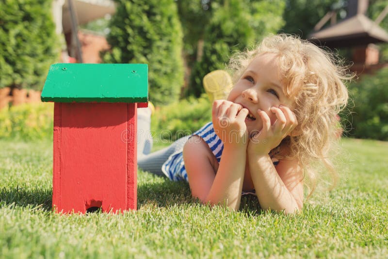Wooden Model Of House And Little Blonde Girl Stock Photo