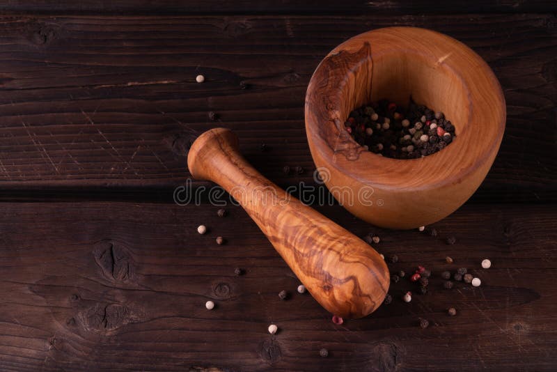 Wooden mortar with pepper, low key, olive wood royalty free stock photos Wooden mortar with pepper, low key, olive wood royalty free stock photos