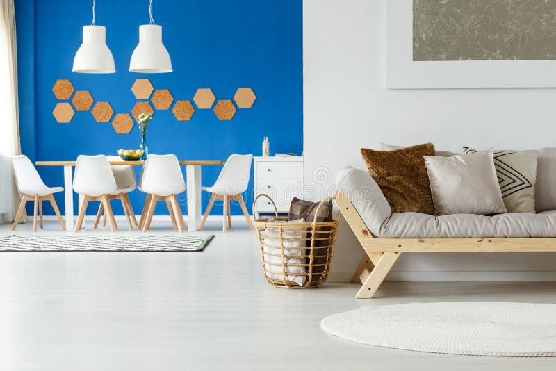 Wooden natural open loft interior. Wooden and natural decor of cozy open loft interior with cork tiles decoration, beige couch, pillows, painting and dining royalty free stock photography Wooden natural open loft interior. Wooden and natural decor of cozy open loft interior with cork tiles decoration, beige couch, pillows, painting and dining royalty free stock photography