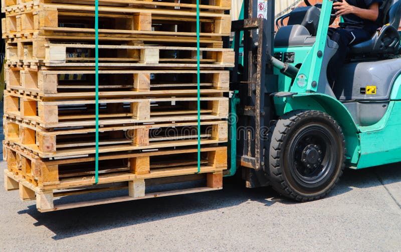 Wooden pallets stack at the freight cargo warehouse for transportation and logistics industrial, Driver forklift loading