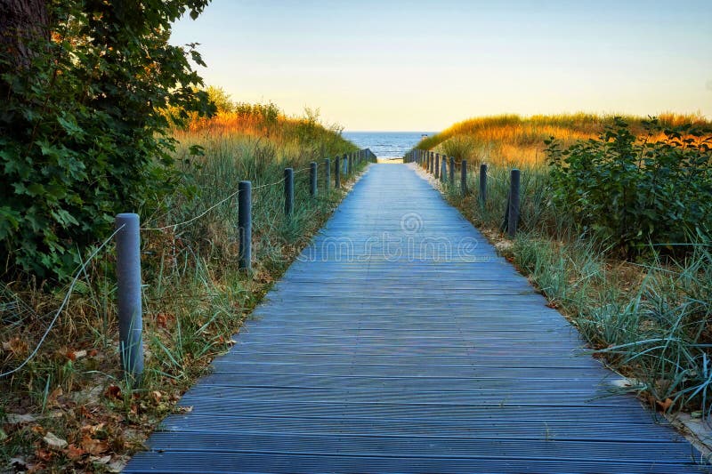 Wooden path to the Baltic sea beach through the sand dunes with sea view. Ahlbeck, Germany