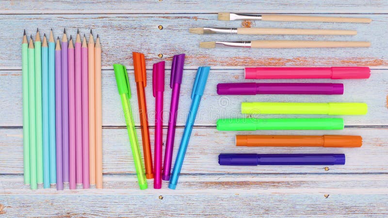 Wooden pens, pencils, felt pens and brushes moving on wooden table. Back to school stop motion