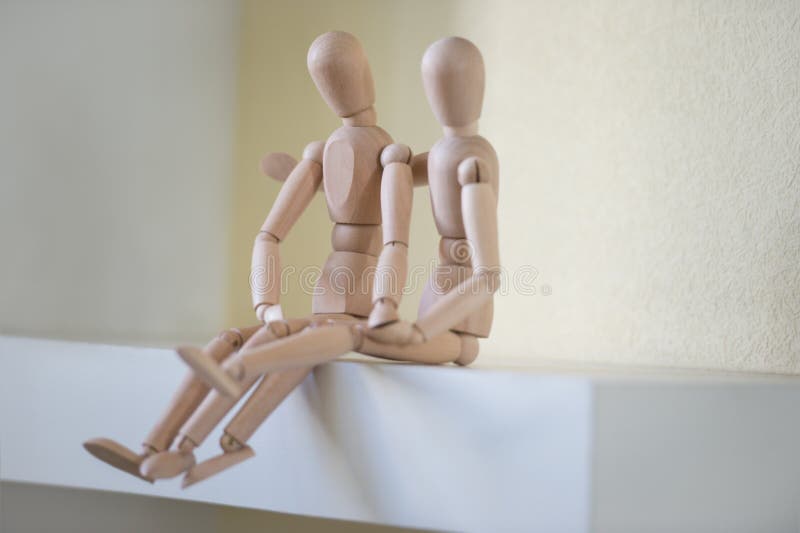 Wooden people sitting at home and hugging. People relationship concept. Little marionette stock images, royalty-free photos and pictures