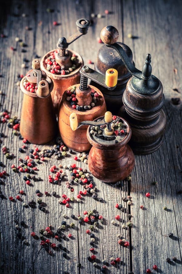 Wooden Pepper Mills with Different Types of Pepper on Table Stock Image