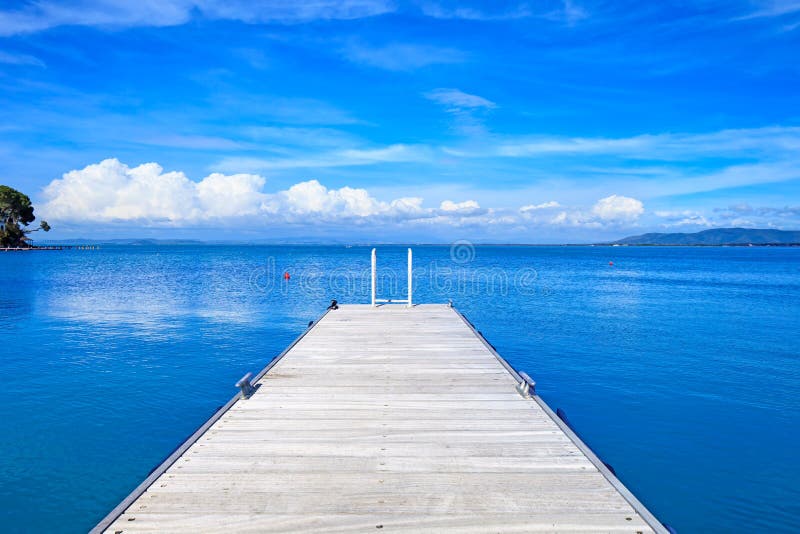 Wooden pier or jetty on a blue ocean. Beach in Argentario, Tuscany, Italy