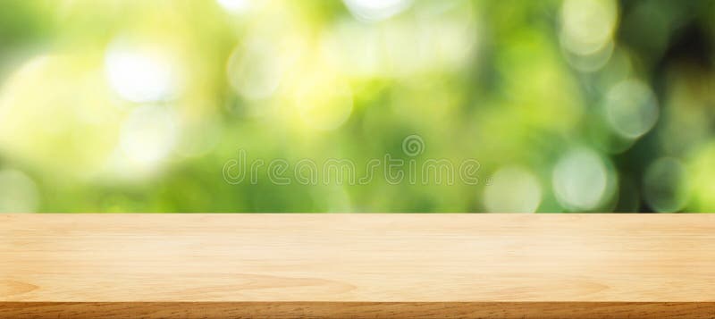 Wooden plank table top with blur tree in park with bokeh light at background,Mock up template for display of your design,Banner