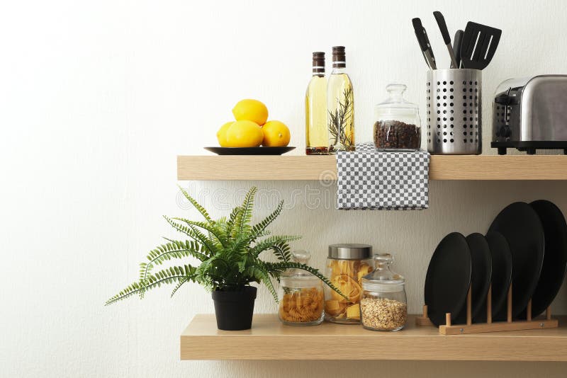 Wooden shelves with dishware and products on wall. Kitchen interior idea