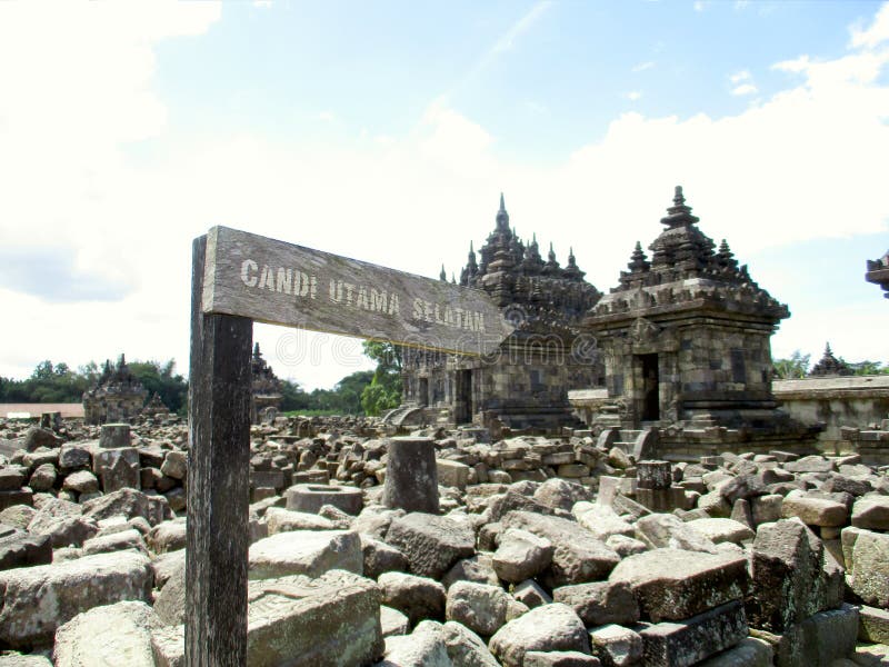 Wooden Signpost board to Main South Temple of Plaosan Temple Candi, Klaten, Indonesia stone rocks ruins background landscape. Wooden Signpost board to Main South royalty free stock images Wooden Signpost board to Main South Temple of Plaosan Temple Candi, Klaten, Indonesia stone rocks ruins background landscape. Wooden Signpost board to Main South royalty free stock images
