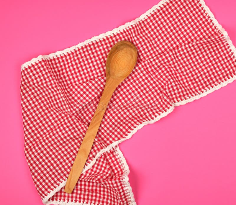 Wooden Spoon on a Red Kitchen Towel, Pink Background Stock Image