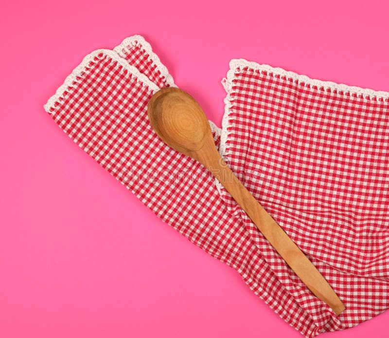 Wooden Spoon on a Red Kitchen Towel, Pink Background Stock Image