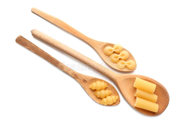 Wooden Spoons with Different Types of Pasta on White Background Stock
