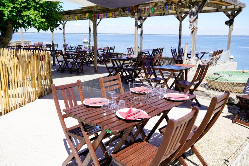 Wooden table on beach terrace for seafood oysters tasting on l`herbe village in Cap Ferret at bay Arcachon basin France