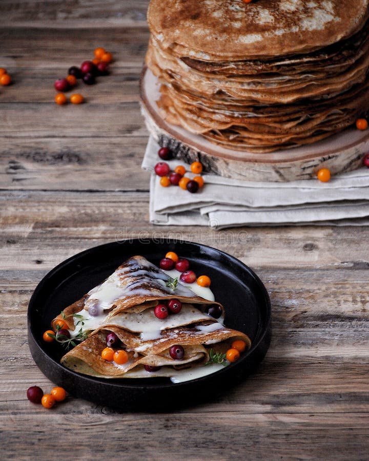 On a Wooden Table on a Stand a Pile of Thin Pancakes with Condensed