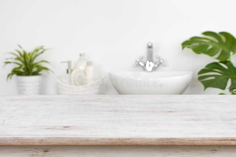 Wooden table top over blurred bathroom interior and spa products