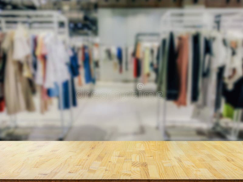 Wooden Top Table with Blurred of Clothes Shop Costume Dress Fashion