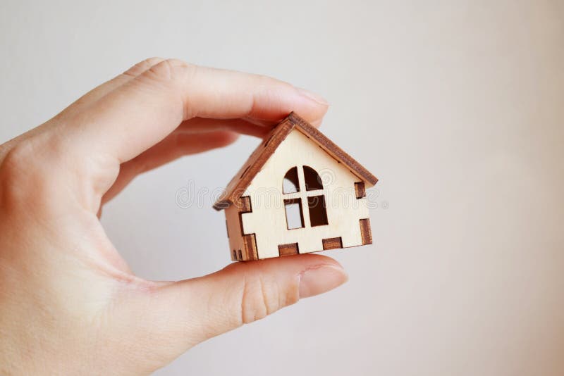 Wooden toy house model in woman`s hand on white background front view royalty free stock images Wooden toy house model in woman`s hand on white background front view royalty free stock images