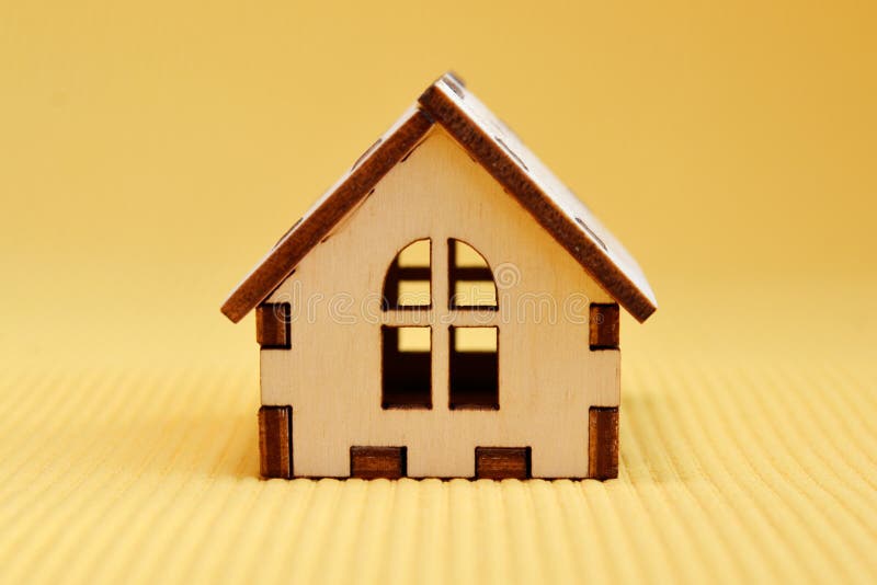 Wooden Toy House Model on Yellow Background Front View Stock Photo
