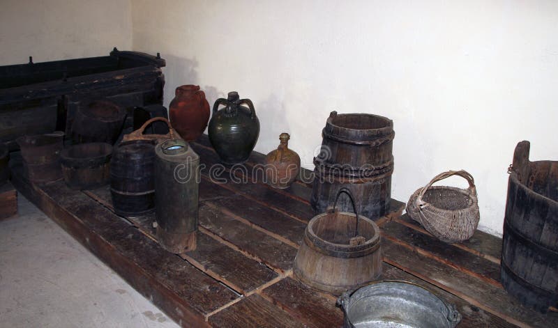 A wooden vat for grape-stomping, buckets and other antique household items in the basement of a traditional Bulgarian village hous