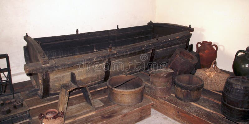 A wooden vat for grape-stomping, buckets and other antique household items in the basement of a traditional Bulgarian village hous
