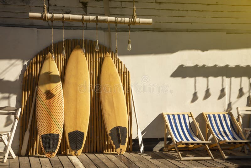 Wooden vintage Surfboard and Bamboo fence stands in the sand